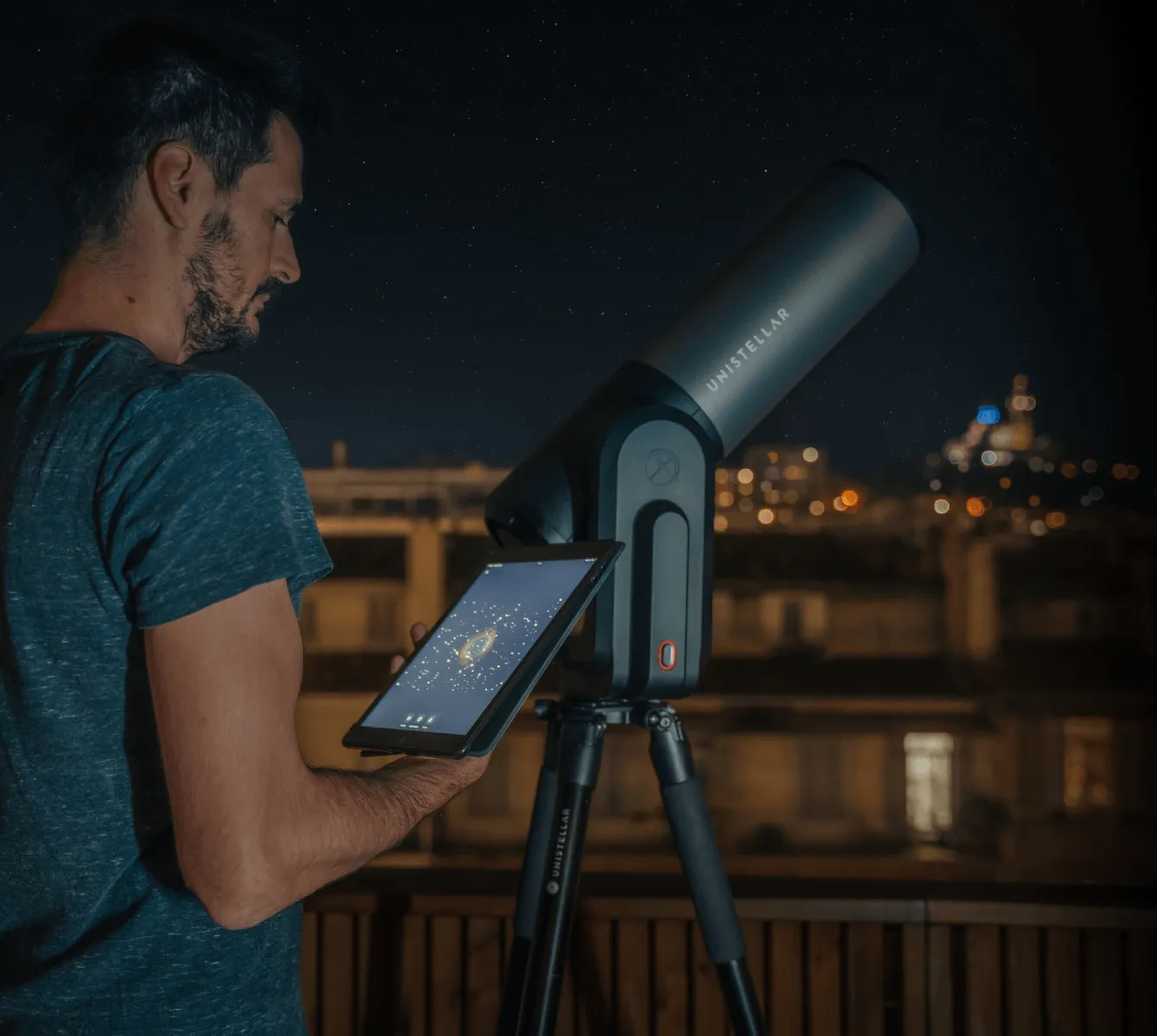 Un uomo pilota l'eQuinox 2 dal suo tablet, su un balcone di notte. Le luci della città illuminano lo sfondo.
