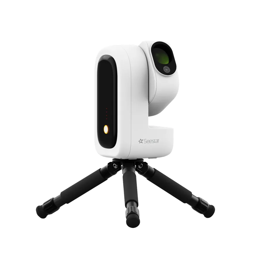 Le Seestar S50 Pro de trois quarts sur son trépied à branches noires. Le corps blanc porte le tube optique relevé, objectif tourné vers le haut.